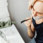 Łysy mężczyzna goli twarz brzytwą na mokro z użyciem kremu