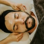 Mężczyzna z trądzikiem różowatym podczas relaksującego masażu twarzy