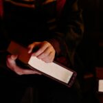 Osoba trzymająca tajemniczą księgę w ciemnym, nastrojowym otoczeniu