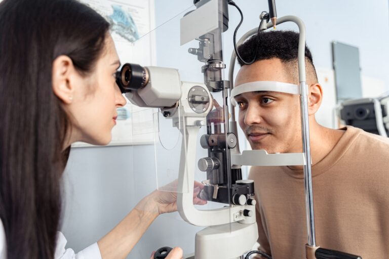 Optometrysta bada oczy pacjenta specjalistycznym sprzętem w gabinecie